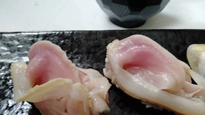 木の器に並べた貝の握り寿司のクローズアップ